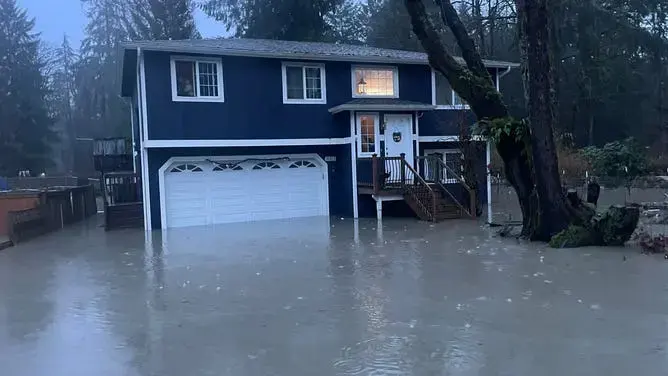 Floodwater standing around a two-story house during a Puget Sound valley storm