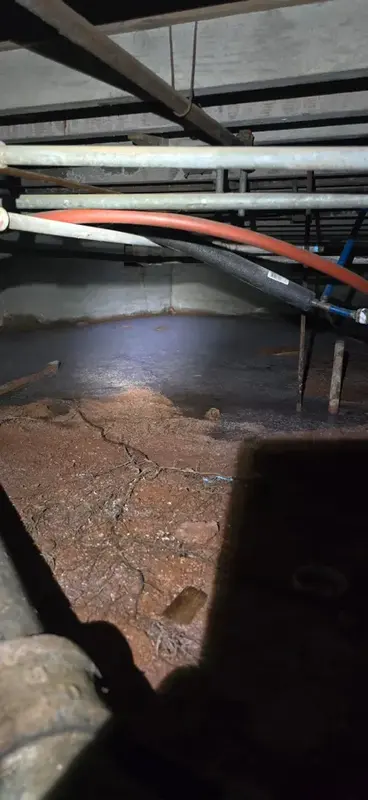 Pipes running above standing water in a crawl space after a freeze
